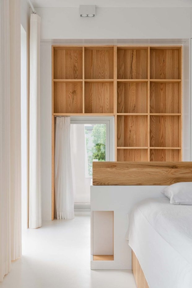 Built-in wooden shelves in a white bedroom
